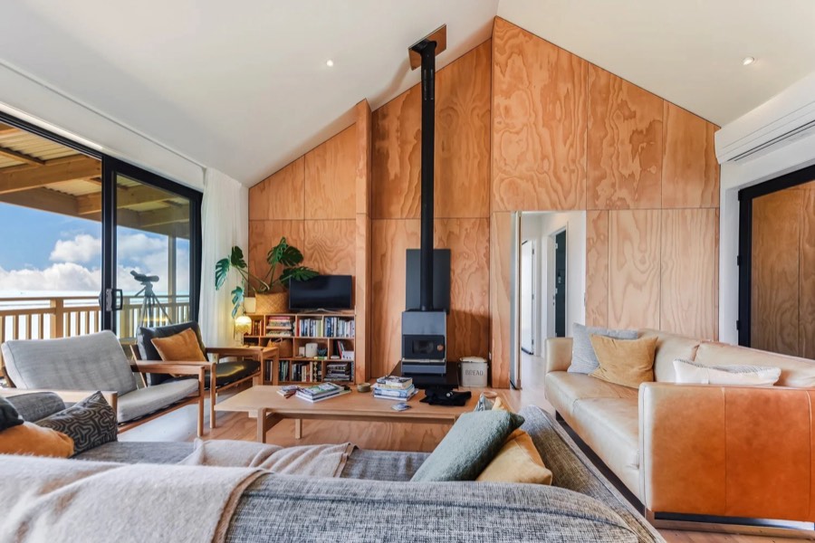 Living room with a timber-lined gable and wood burner, built by Aspect Builders